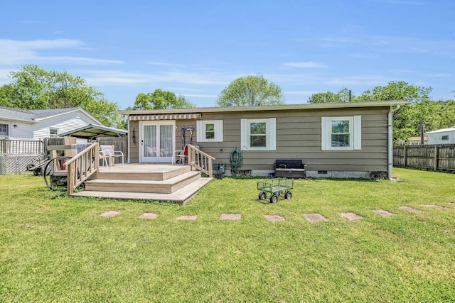 back of property with a deck, crawl space, a fenced backyard, and a lawn