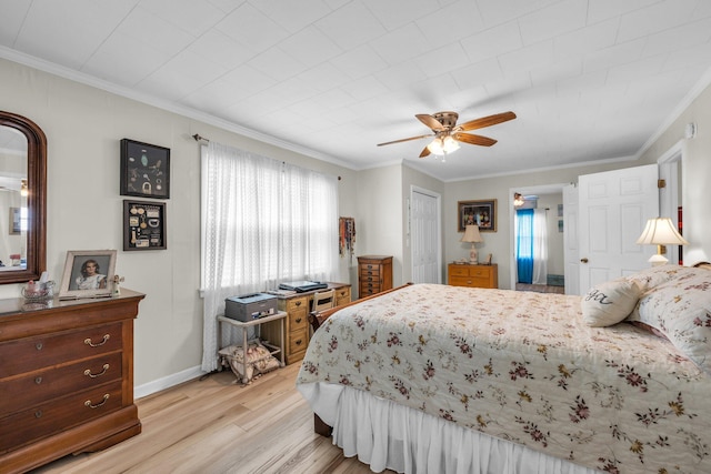 bedroom featuring ceiling fan, light wood-style flooring, baseboards, a closet, and crown molding