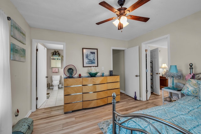 bedroom with light wood-type flooring, baseboards, and ensuite bathroom