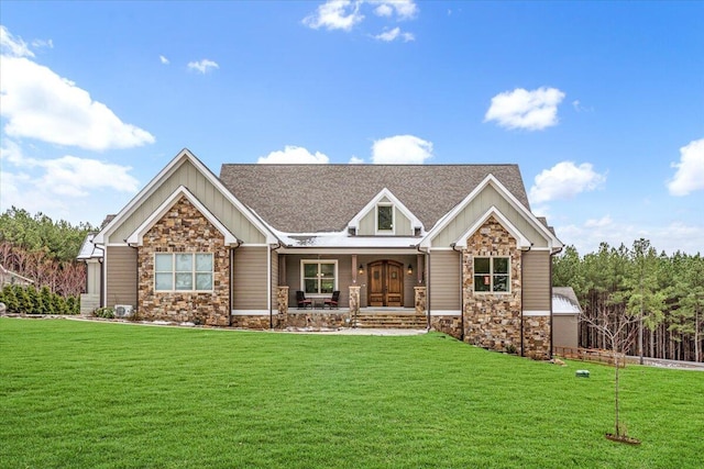 view of front of home featuring stone siding, board and batten siding, and a front yard