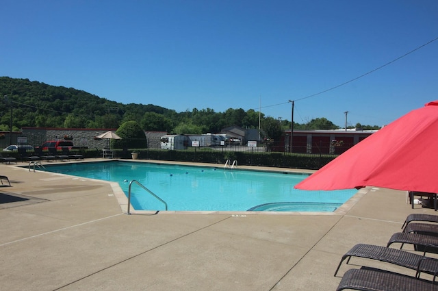 pool with a patio area and fence