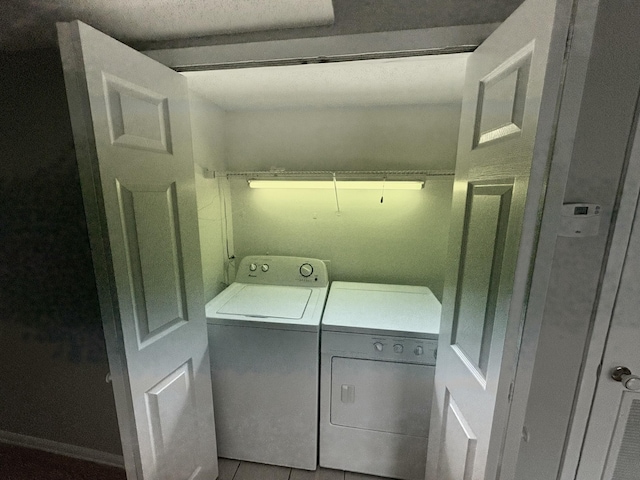 laundry room featuring tile patterned flooring, laundry area, and washer and clothes dryer