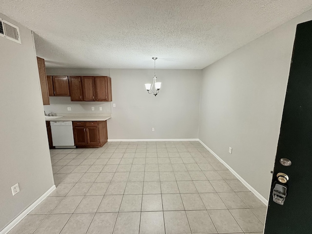 kitchen with visible vents, baseboards, light countertops, dishwasher, and an inviting chandelier