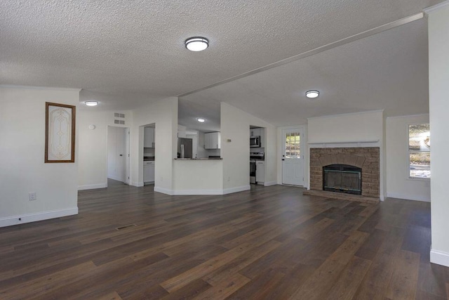 unfurnished living room with dark wood-style floors, a glass covered fireplace, and a healthy amount of sunlight