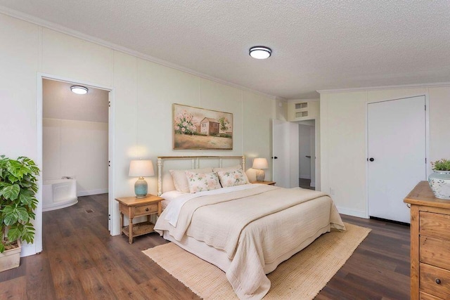 bedroom with a textured ceiling, ornamental molding, and dark wood-style flooring