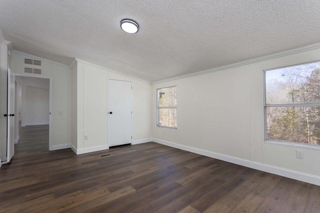 unfurnished bedroom featuring a textured ceiling, baseboards, vaulted ceiling, ornamental molding, and dark wood-style floors