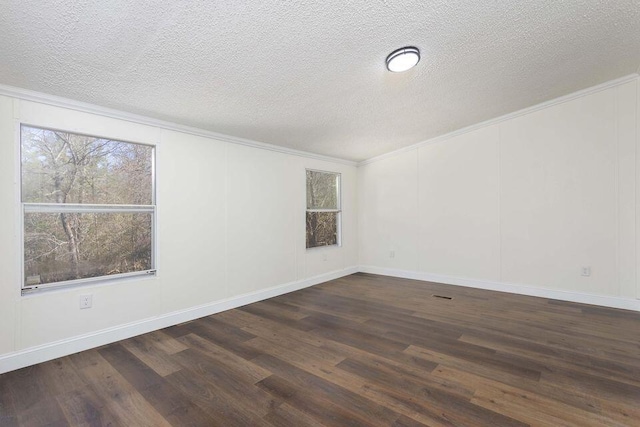 spare room with dark wood-type flooring, ornamental molding, a textured ceiling, and a decorative wall