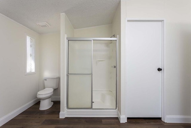 bathroom featuring a textured ceiling, a shower stall, baseboards, and wood finished floors