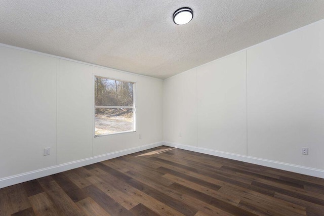 spare room with a textured ceiling, baseboards, and dark wood-style flooring