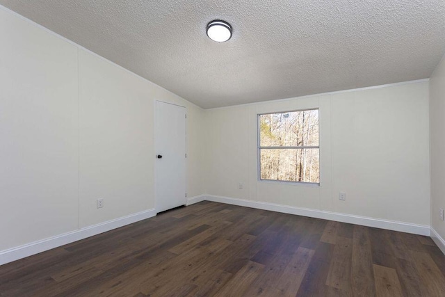 empty room with a textured ceiling, baseboards, vaulted ceiling, and dark wood-style flooring