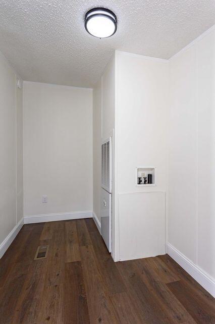 clothes washing area featuring dark wood-style floors, washer hookup, visible vents, a textured ceiling, and laundry area