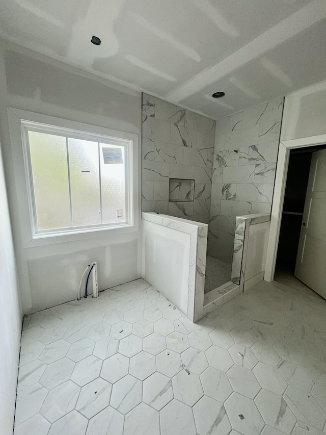 full bath with a marble finish shower
