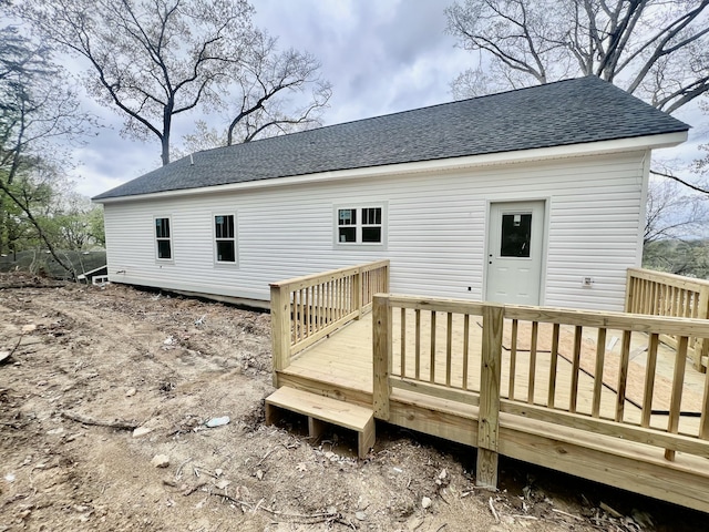 rear view of house with a wooden deck and roof with shingles
