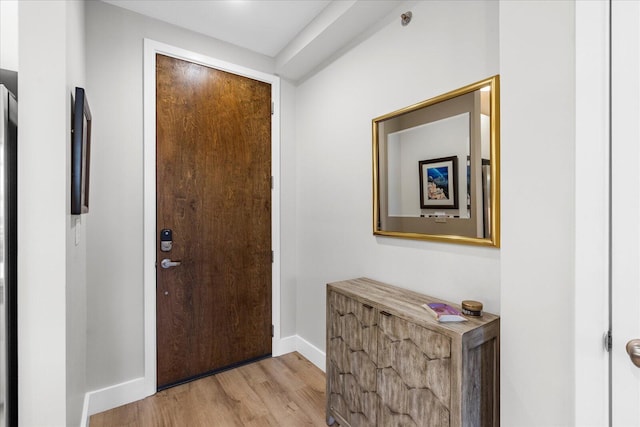 foyer with light wood-type flooring and baseboards