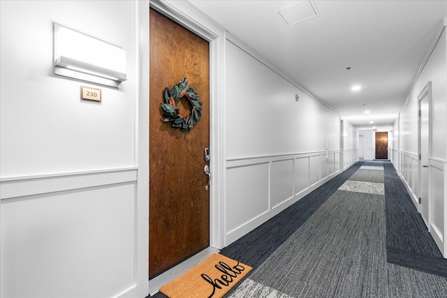 corridor with a wainscoted wall and a decorative wall