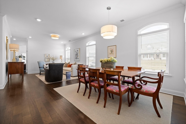 dining space with dark wood-type flooring, a healthy amount of sunlight, and ornamental molding