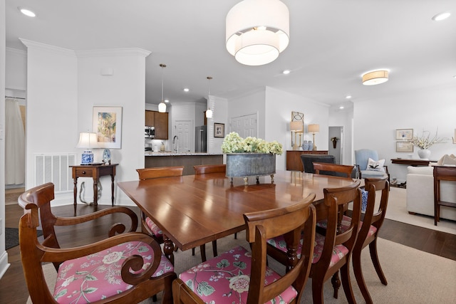 dining room with dark wood-style flooring, recessed lighting, visible vents, and crown molding