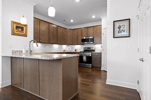 kitchen featuring appliances with stainless steel finishes, dark wood-type flooring, a peninsula, light stone countertops, and a sink