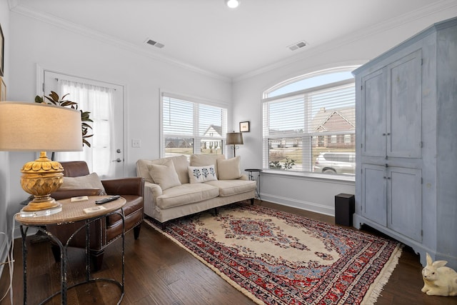 living area featuring baseboards, visible vents, dark wood finished floors, and crown molding