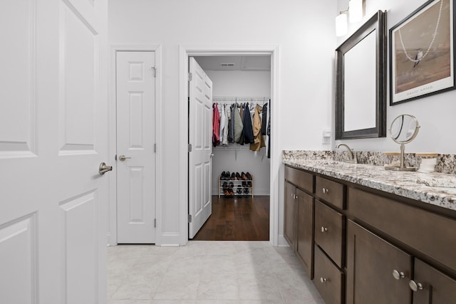 bathroom featuring a walk in closet and vanity