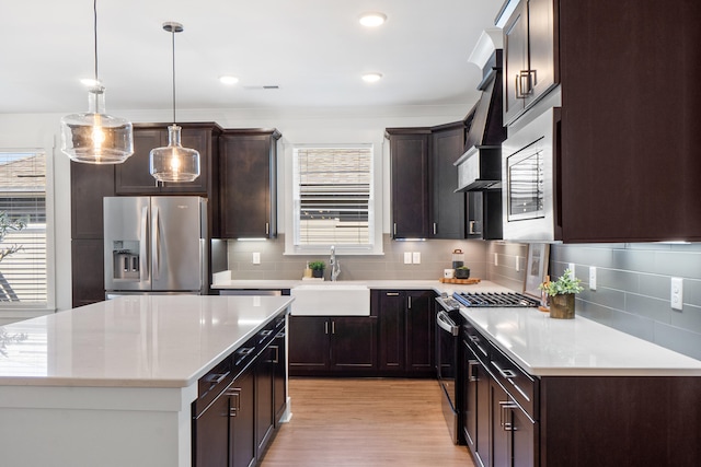 kitchen with light countertops, appliances with stainless steel finishes, and decorative light fixtures