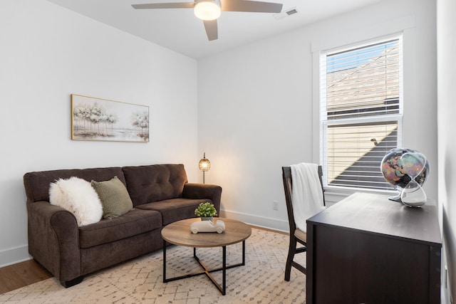 interior space featuring light wood finished floors, baseboards, visible vents, and ceiling fan