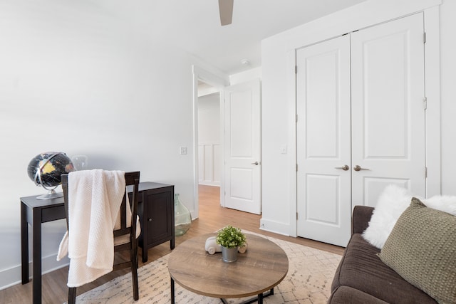 home office featuring light wood-type flooring, ceiling fan, and baseboards