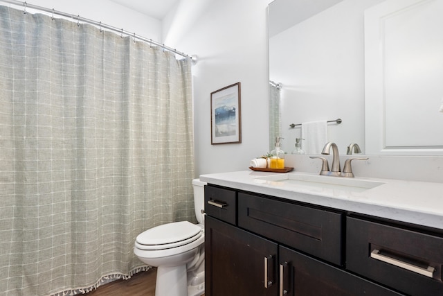 bathroom with toilet, wood finished floors, and vanity