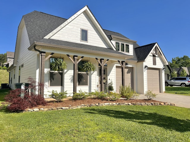 view of front of home with a front yard, covered porch, roof with shingles, and driveway