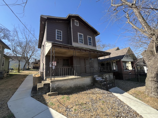 view of front of home featuring a porch and fence