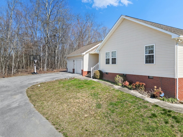 view of property exterior with a yard, an attached garage, entry steps, crawl space, and driveway