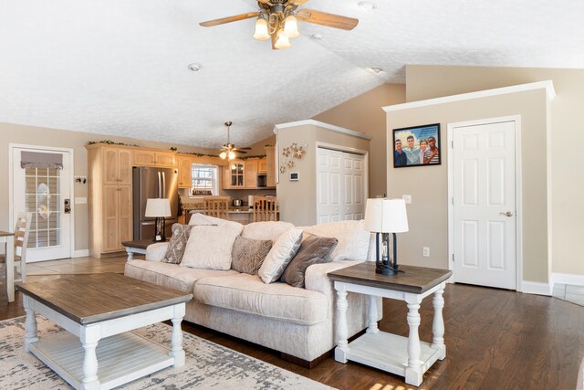 living room featuring dark wood-style floors, lofted ceiling, baseboards, and a ceiling fan