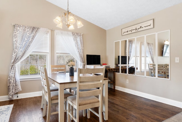 dining space featuring baseboards, lofted ceiling, dark wood-style floors, a textured ceiling, and a notable chandelier
