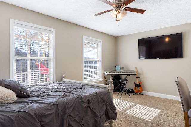 bedroom featuring carpet floors, ceiling fan, baseboards, and a textured ceiling