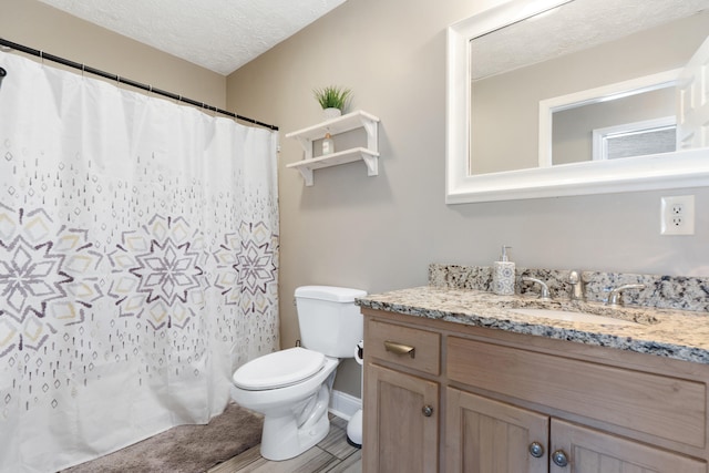 full bathroom with curtained shower, toilet, a textured ceiling, and vanity