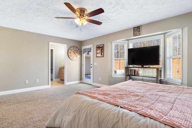 bedroom with light carpet, multiple windows, baseboards, and a textured ceiling