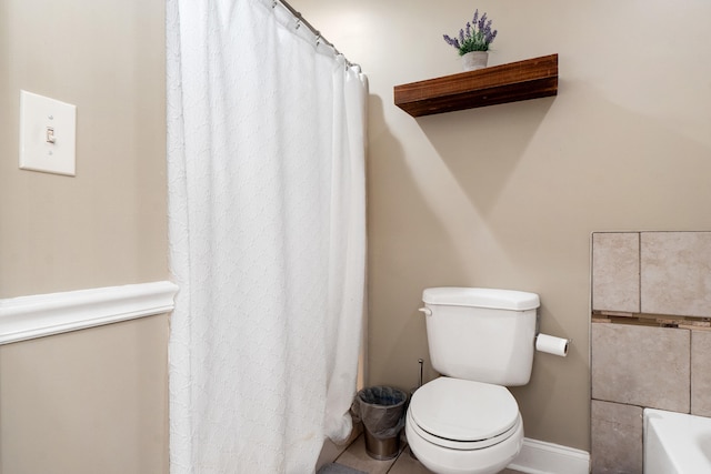 full bath with a bathtub, toilet, and baseboards