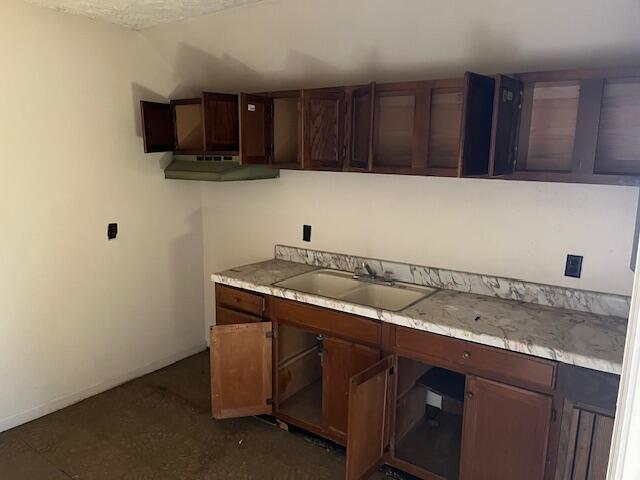 kitchen with dark brown cabinets, light countertops, and a sink