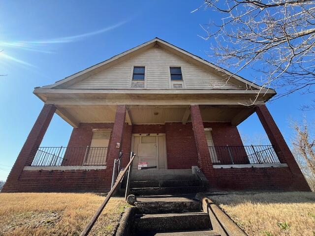 view of front of property with a porch and a front yard