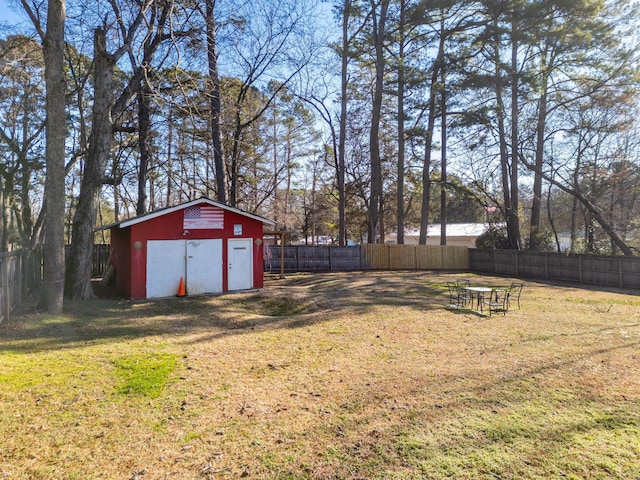 view of yard with a fenced backyard, an outdoor structure, and a storage unit