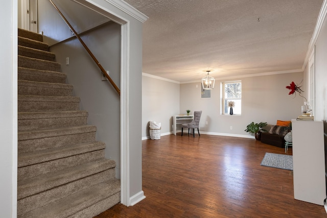 stairs featuring baseboards, wood finished floors, an inviting chandelier, crown molding, and a textured ceiling