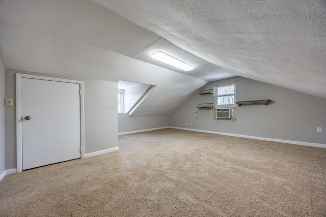 additional living space with lofted ceiling, baseboards, a textured ceiling, and carpet flooring