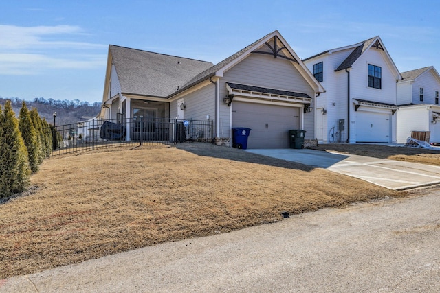 view of front of home featuring an attached garage, fence, and concrete driveway