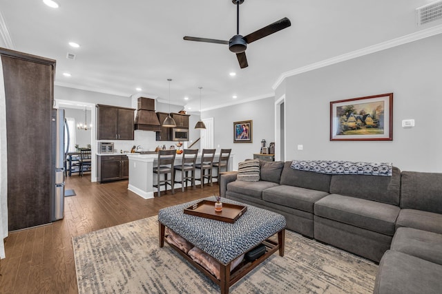 living area featuring visible vents, a ceiling fan, dark wood-style floors, crown molding, and recessed lighting