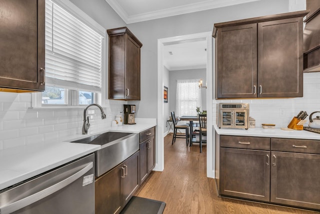 kitchen with dark brown cabinetry, dishwasher, ornamental molding, light countertops, and light wood-type flooring