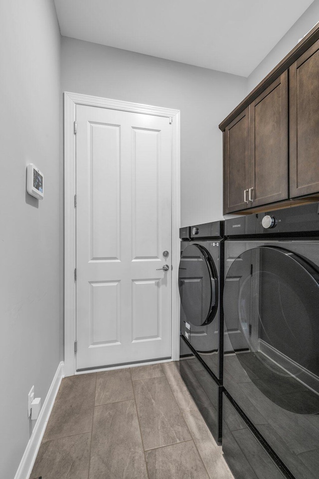 laundry area with cabinet space, baseboards, and washing machine and clothes dryer