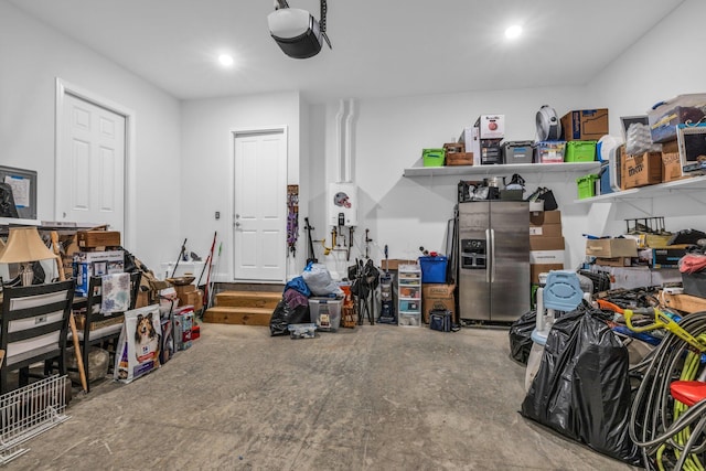 garage featuring a garage door opener, recessed lighting, and stainless steel fridge with ice dispenser