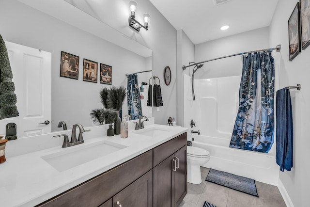 bathroom featuring tile patterned floors, a sink, toilet, and shower / tub combo with curtain