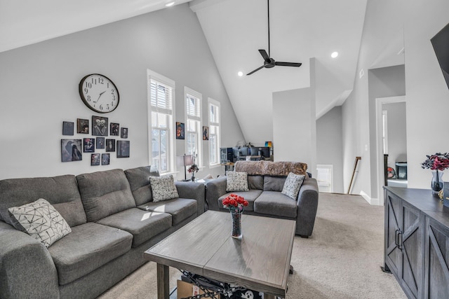 living area with baseboards, visible vents, a ceiling fan, light colored carpet, and high vaulted ceiling