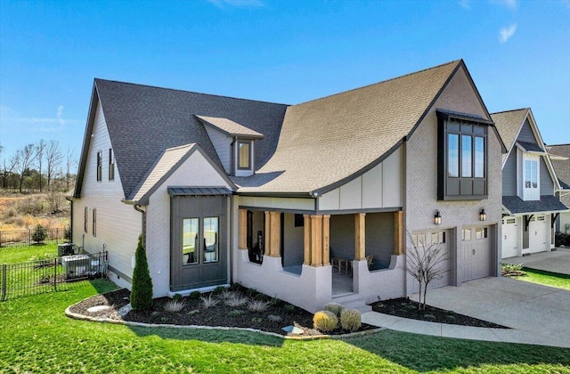 view of front of home with a porch, a garage, fence, driveway, and a front yard